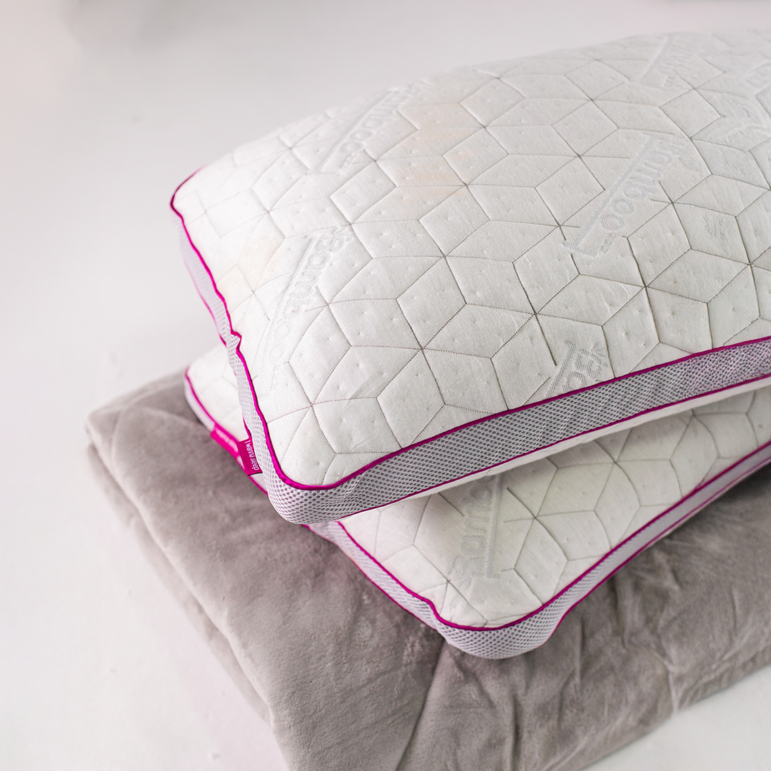 SnowTouch adjustable memory foam pillow on bed with blanket